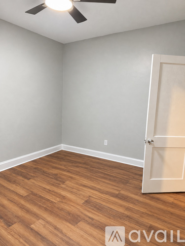 A room with a wooden floor and a ceiling fan.