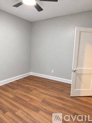 A room with a wooden floor and a ceiling fan.