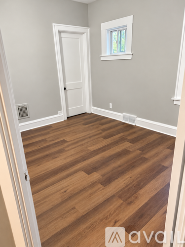 A room with wooden flooring and a white door.