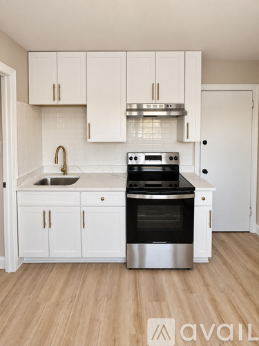 A kitchen with white cabinets and a stainless steel oven.