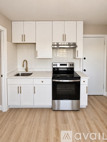 A kitchen with white cabinets and a stainless steel oven.
