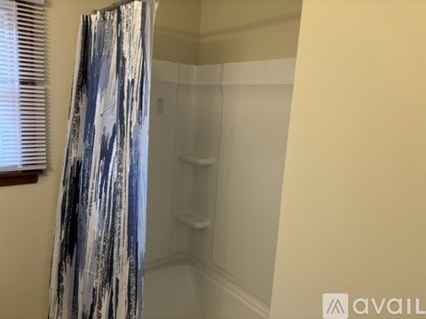 A shower area with a glass door and a shower curtain.