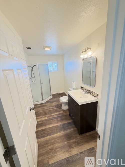 A bathroom with a toilet, sink, and shower.