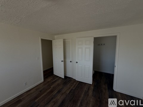 A room with white doors and wooden floors.