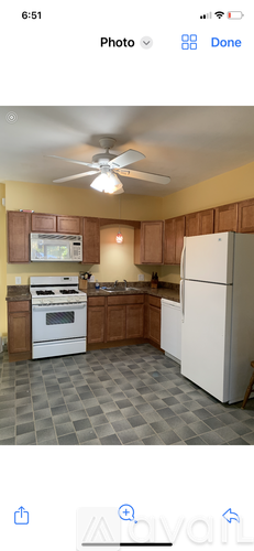 A kitchen with a white refrigerator and a ceiling fan.