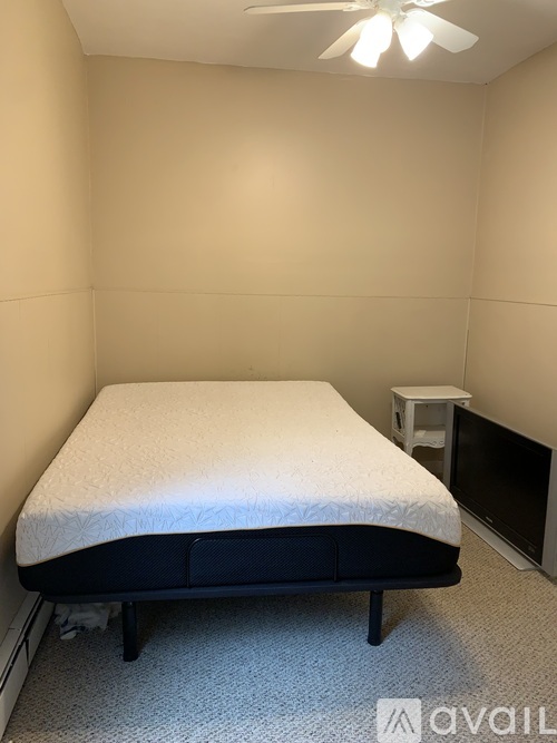 A bedroom with a bed, a small table, and a television.