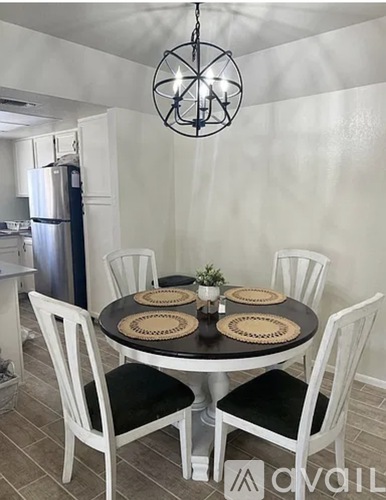 A dining room with a round table and chairs.