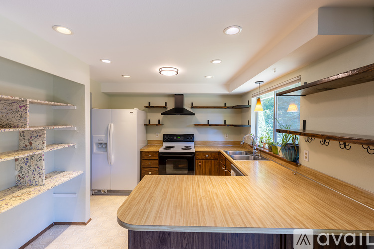 A kitchen with a wooden counter top and a refrigerator.