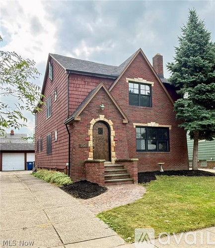 A red brick house with a large front yard.