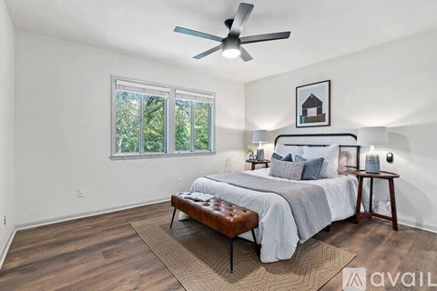 A bedroom with a large bed and a ceiling fan.