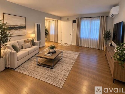 A living room with a couch, a coffee table, and a television.