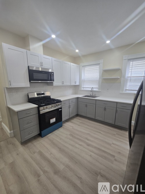 A kitchen with white cabinets and a black stove top oven.
