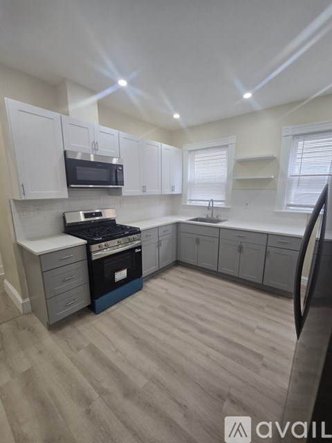 A kitchen with white cabinets and a black stove top oven.