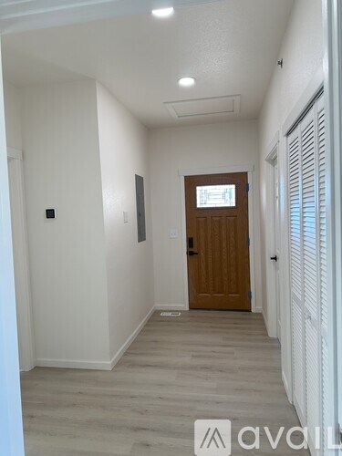 A hallway with a wooden door and white walls.