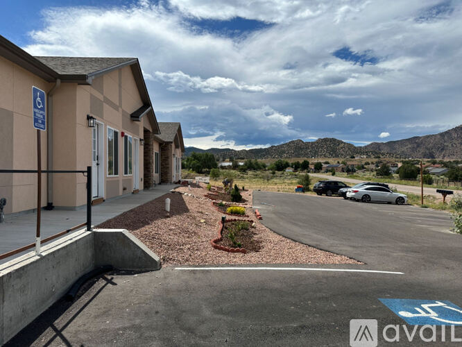 A parking lot with a building and a car parked in front of it.