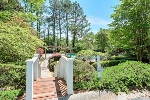 A garden with a white fence and a wooden walkway.