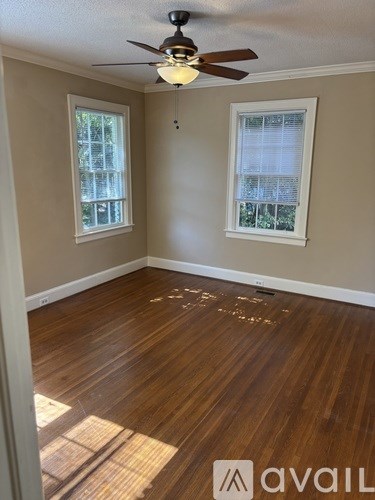 A room with wooden floors and a ceiling fan.