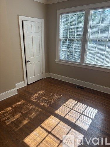 A room with a white door and a window with blinds.