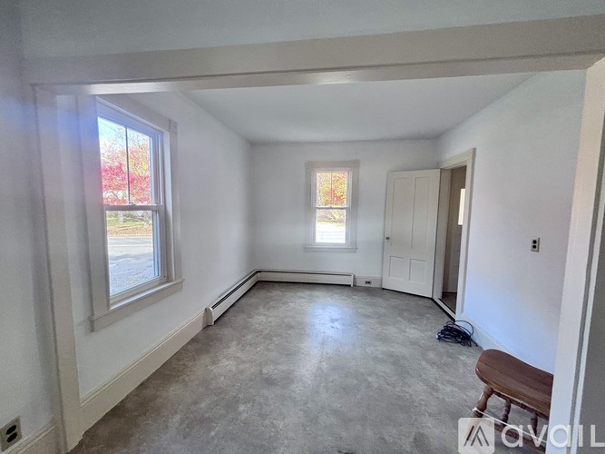 A room with a window and a bench in it.