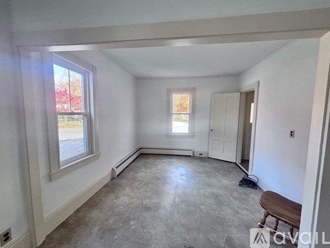 A room with a window and a bench in it.