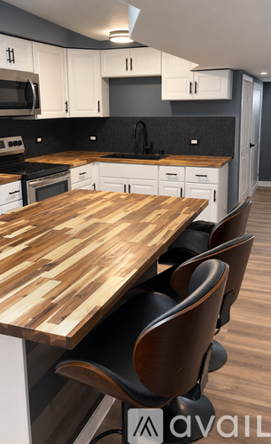 A kitchen with a wooden table and chairs.