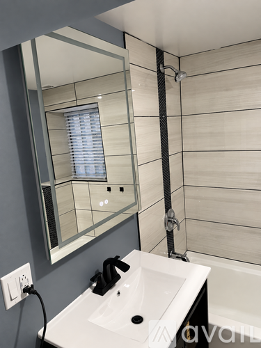 A modern bathroom with a white sink and a large mirror.