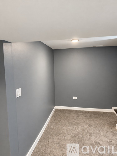 A room with grey walls and carpeted floor.
