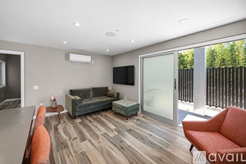 A living room with a grey couch and a wooden floor.