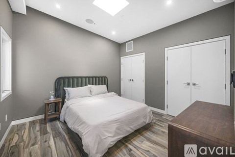 A bedroom with a bed, nightstand, and a wooden bench.