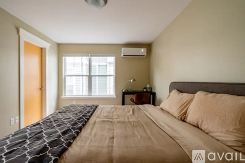 A bedroom with a large bed and a window.