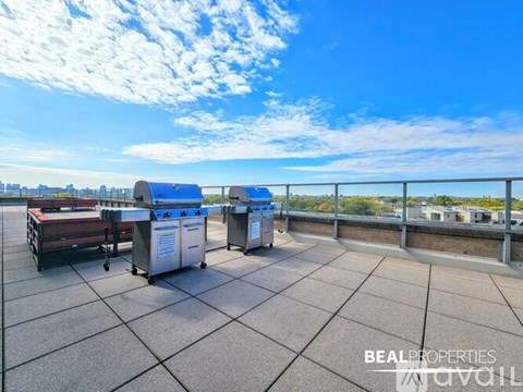 A rooftop with a series of bins and a railing.