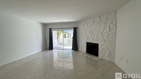 A spacious living room with a fireplace and a sliding glass door.