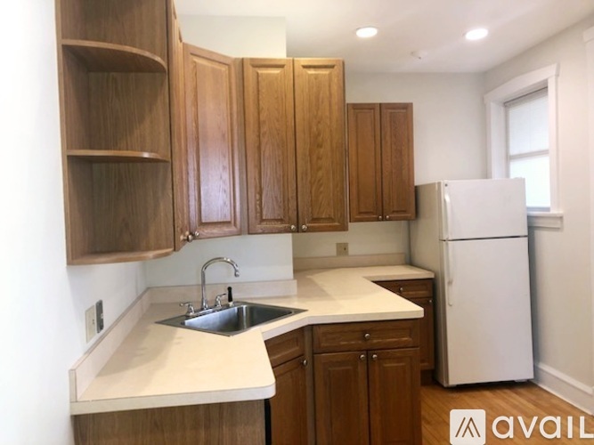 A kitchen with wooden cabinets and a white refrigerator.