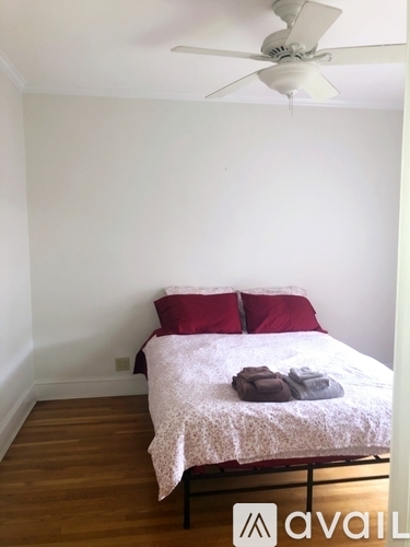 A bedroom with a bed and a ceiling fan.