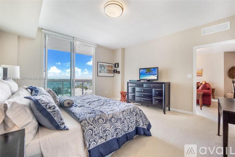 A bedroom with a large bed and a flat screen TV.