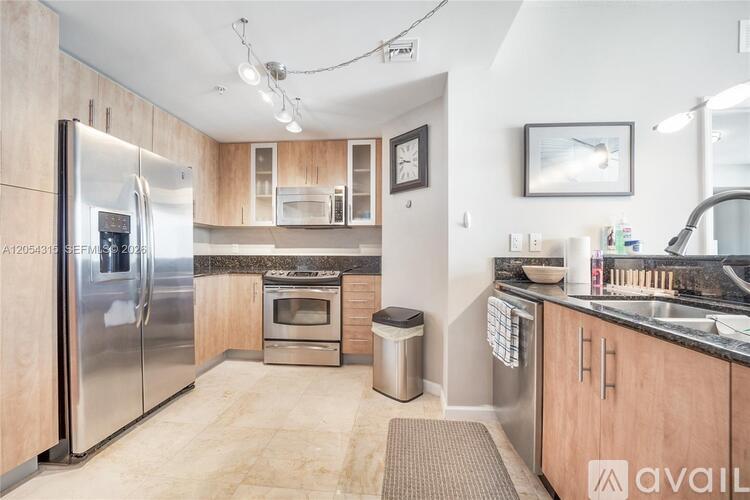 A kitchen with wooden cabinets and a stainless steel refrigerator.