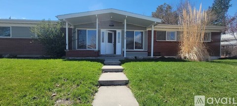 A house with a red brick exterior and a white door is for sale.