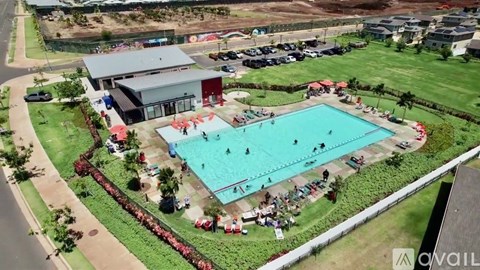 An aerial view of a pool surrounded by a grassy area with people enjoying the water.