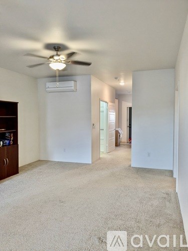 A spacious room with a ceiling fan and carpeted floor.