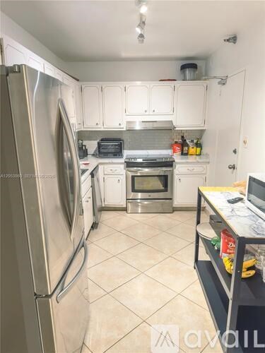 A kitchen with a refrigerator, oven, and microwave.