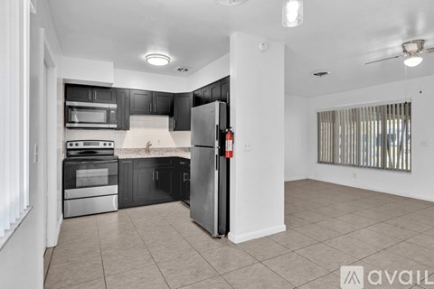 A kitchen with black cabinets and stainless steel appliances.