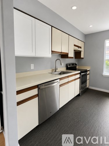 A kitchen with white cabinets and a stainless steel dishwasher.