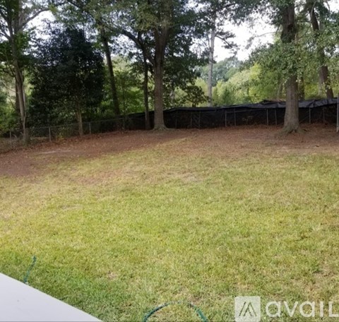 A backyard with a fence and trees.