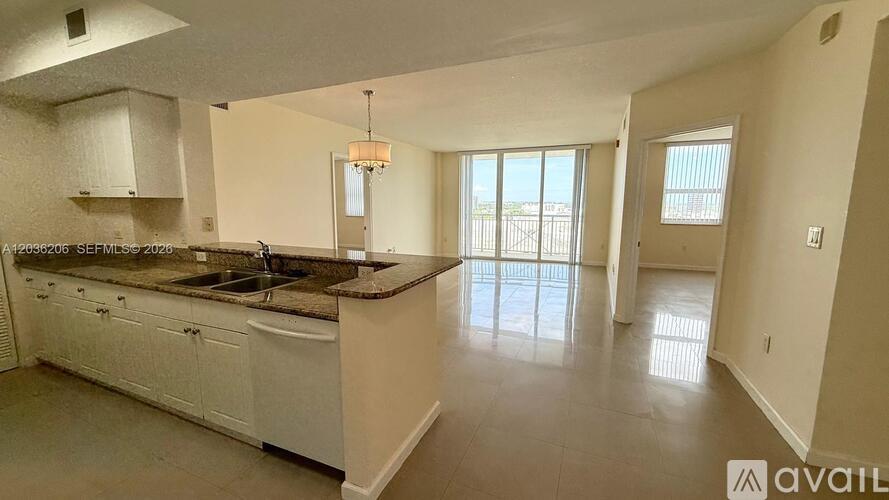 A kitchen with white cabinets and a brown granite countertop.