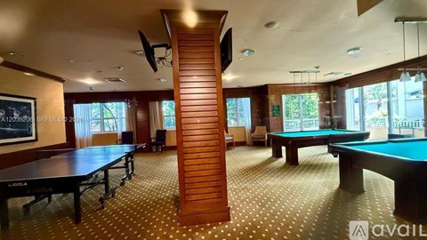 A room with a pool table and a billiard table.
