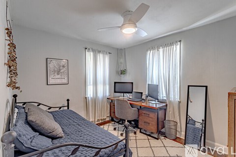 A bedroom with a bed, desk, and chair.