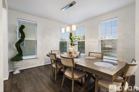 A dining room with a wooden table and chairs.