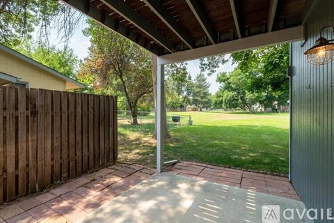 A patio area with a wooden fence and a covered walkway.