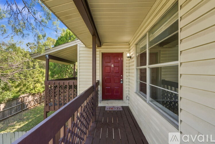 A red door is on the left side of a house.