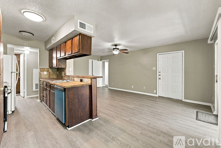 A kitchen with a wooden island and a ceiling fan.